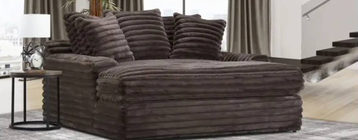 Gray plush chaise lounge in modern room.
