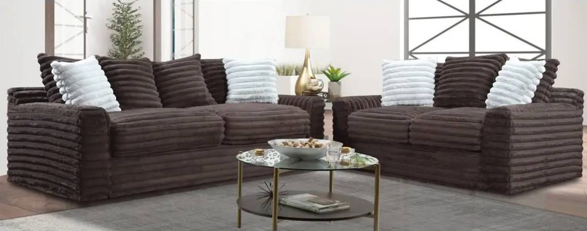 Brown sofas with white pillows in living room.