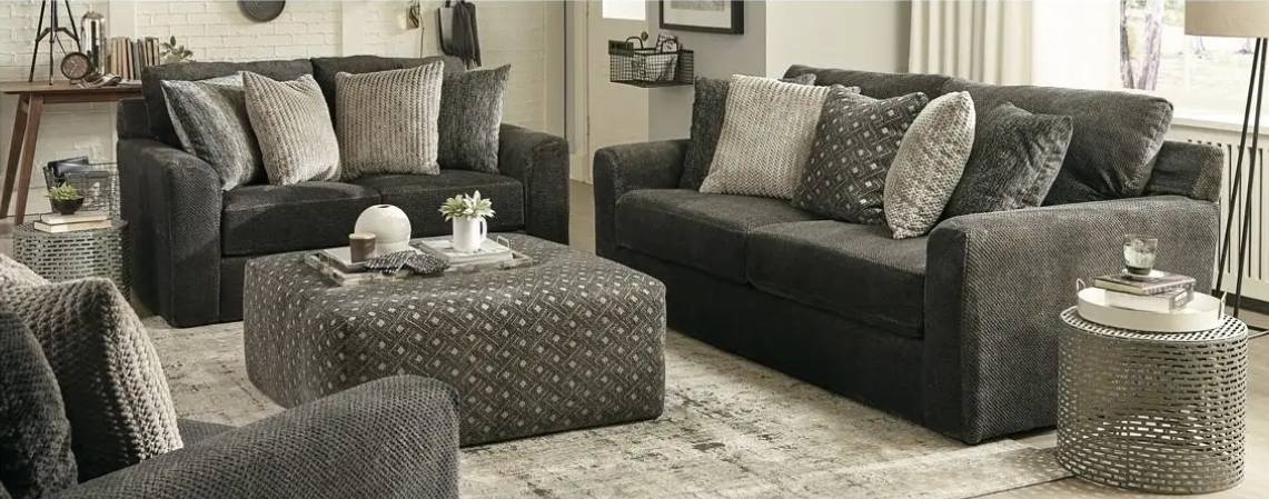 Gray modern living room with sofas and ottoman.