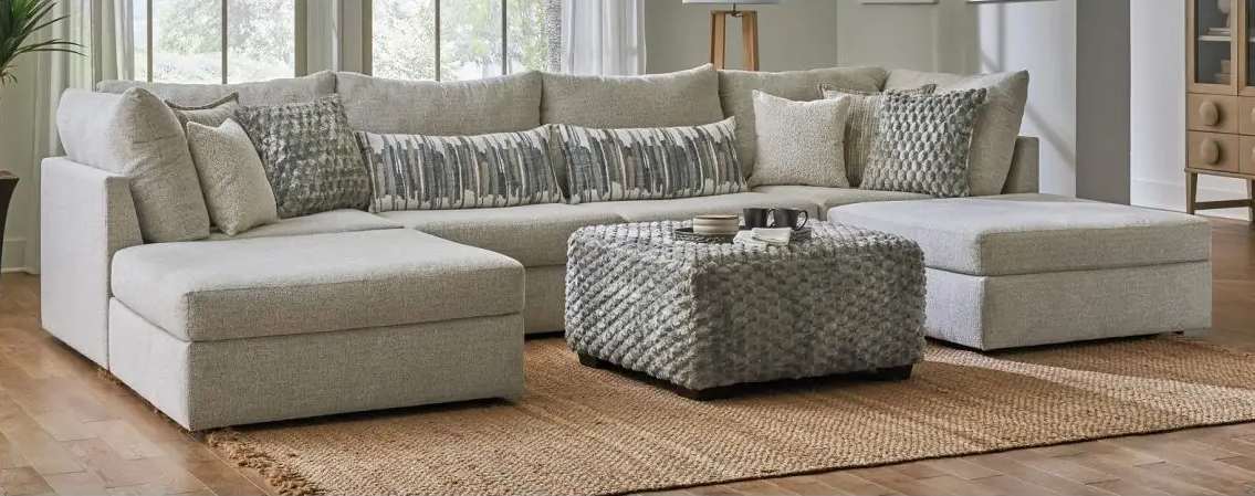 Gray sectional sofa with patterned pillows.