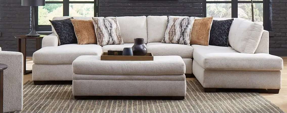 Contemporary beige sectional sofa with patterned pillows.
