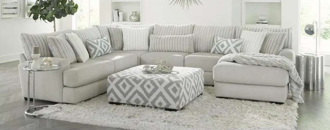 Modern beige sectional sofa with patterned ottoman.